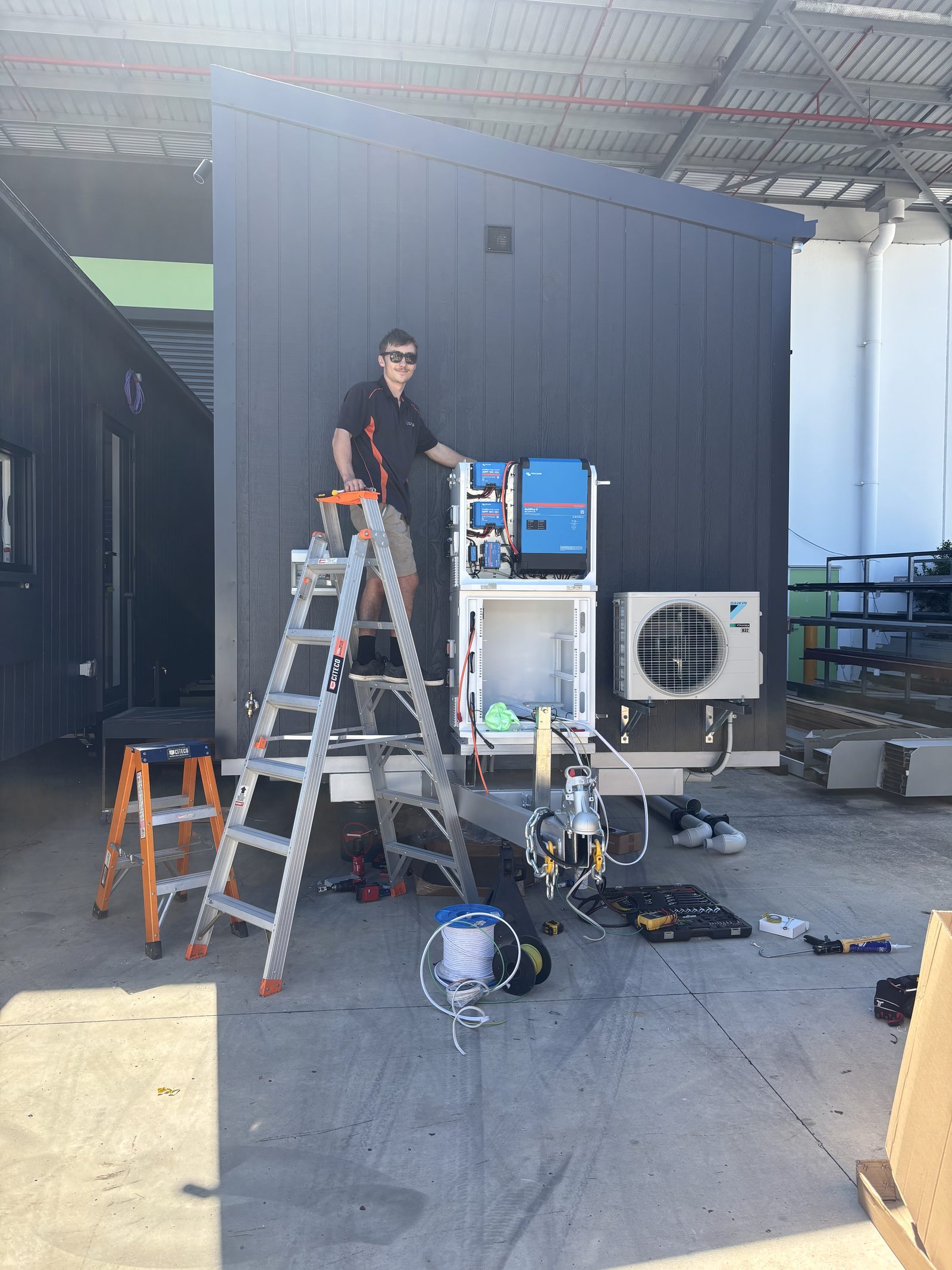 Maxxiom technician installing a PowerBox on a tiny home